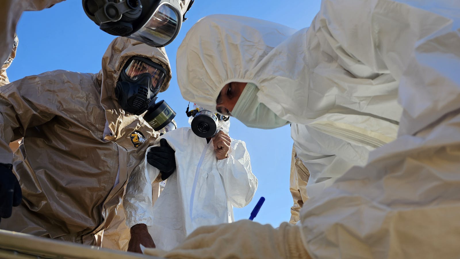 Protective-suit technicians conducting a field inspection
